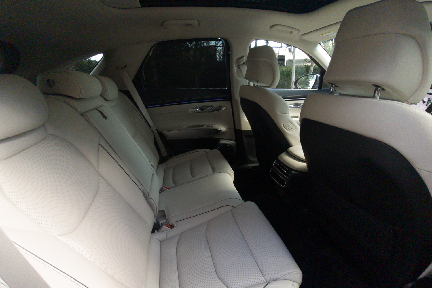 Rear seats of the 2026 Genesis GV70 2.5T Advanced in cream leather with the door sunshade raised