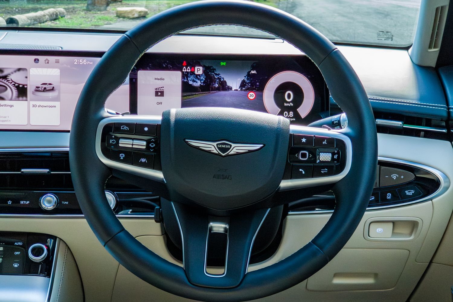 2026 Genesis GV70 2.5T Advanced two-spoke steering wheel with the digital cluster showing the blind-spot camera view