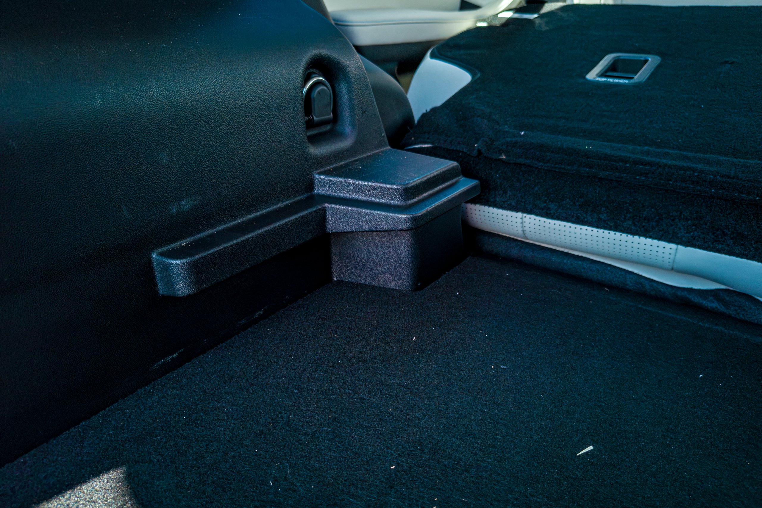 Boot floor corner of the 2026 Jaecoo J5 EV Summit showing the carpeted floor, side ledge and folded seat edge