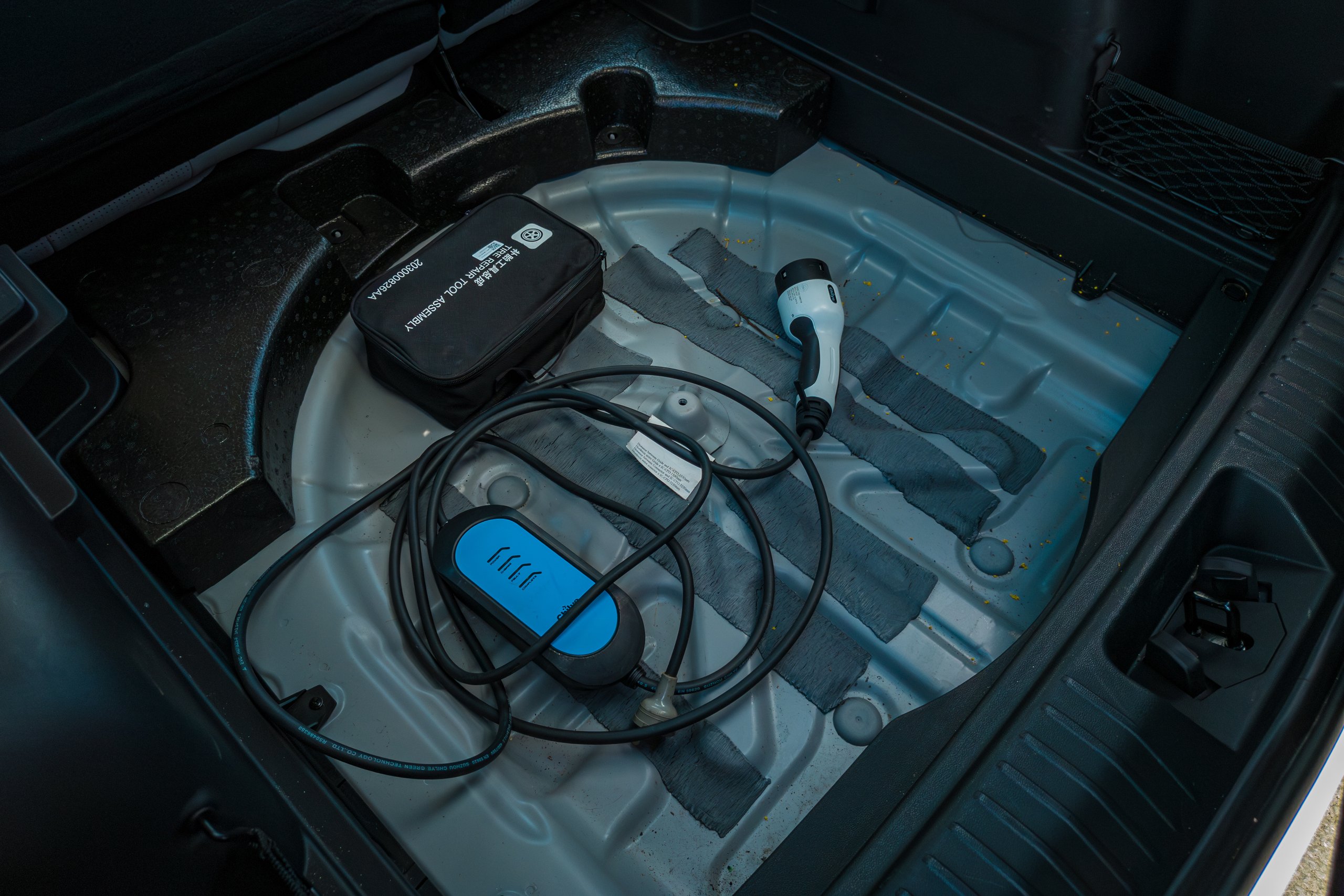 Under-floor boot storage in the 2026 Jaecoo J5 EV Summit holding the portable charging cable and tool kit
