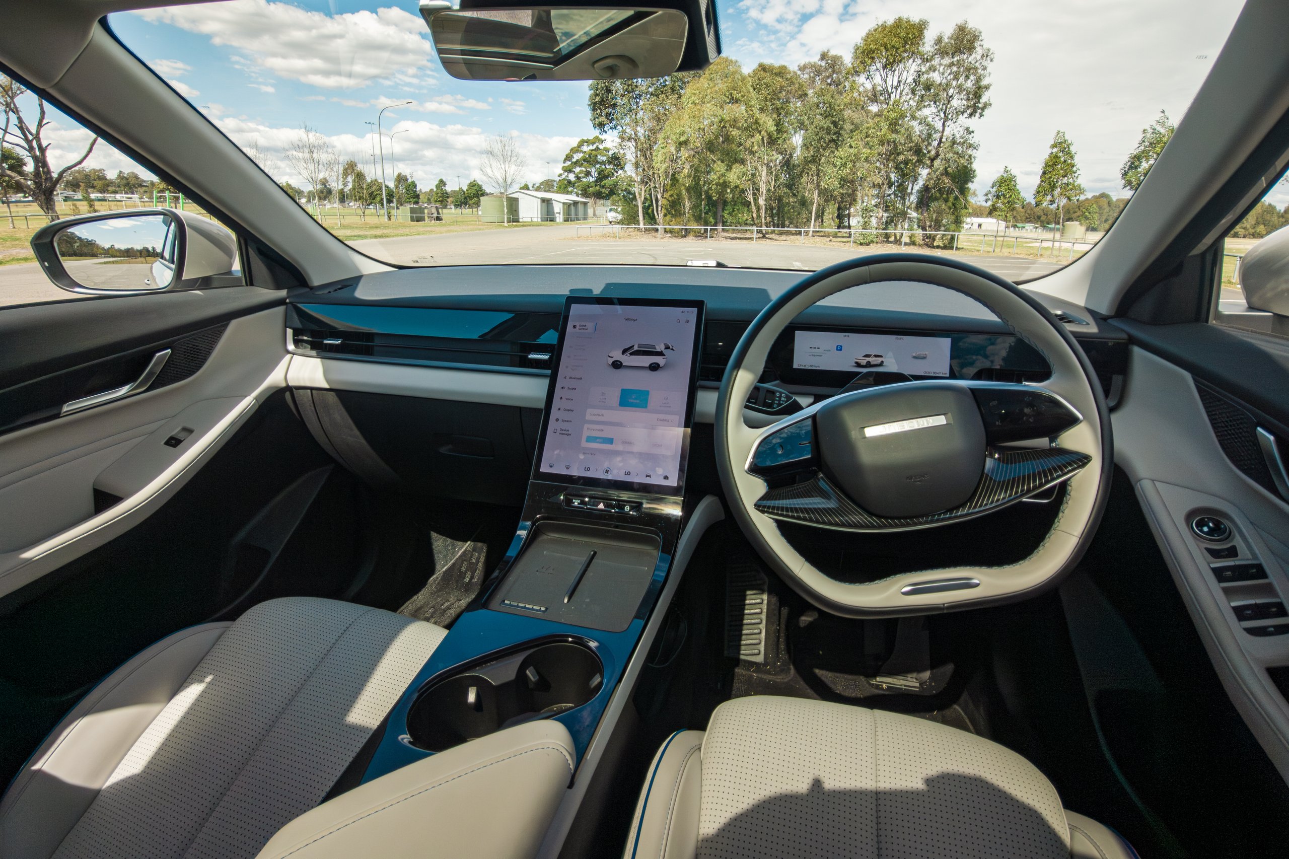 Dashboard of the 2026 Jaecoo J5 EV Summit viewed from between the front seats showing the screen, wheel and blue trim
