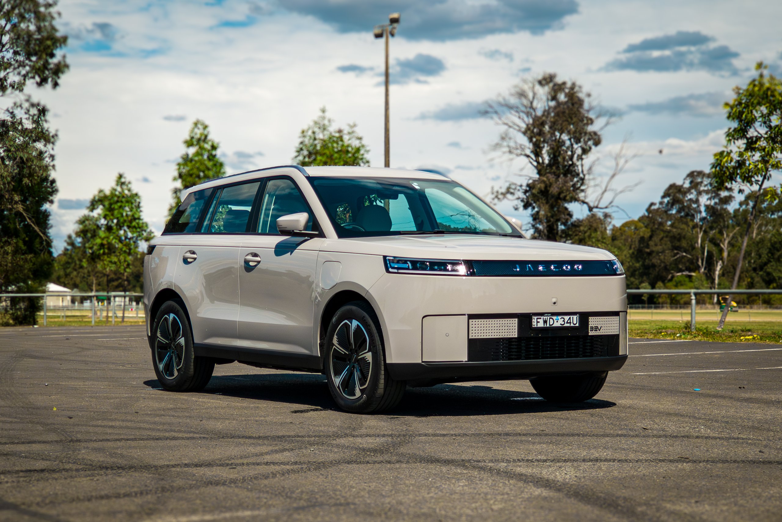 Wide passenger-side front three-quarter of the Stone Grey 2026 Jaecoo J5 EV Summit under a cloudy sky