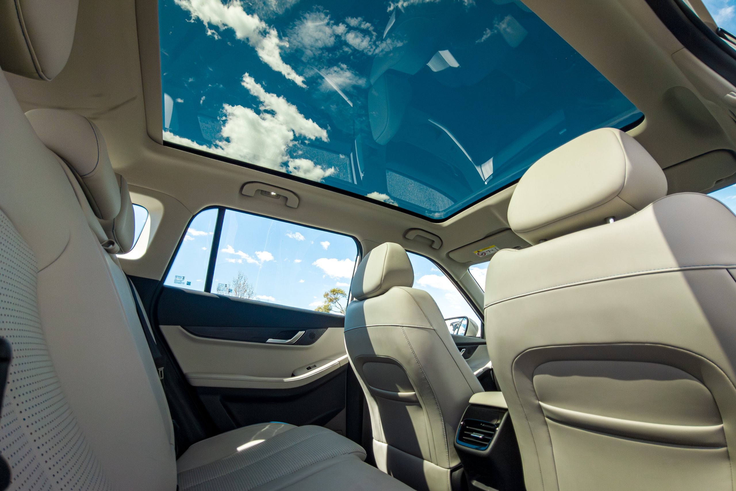 Panoramic glass roof of the 2026 Jaecoo J5 EV Summit viewed from the rear seat with clouds above
