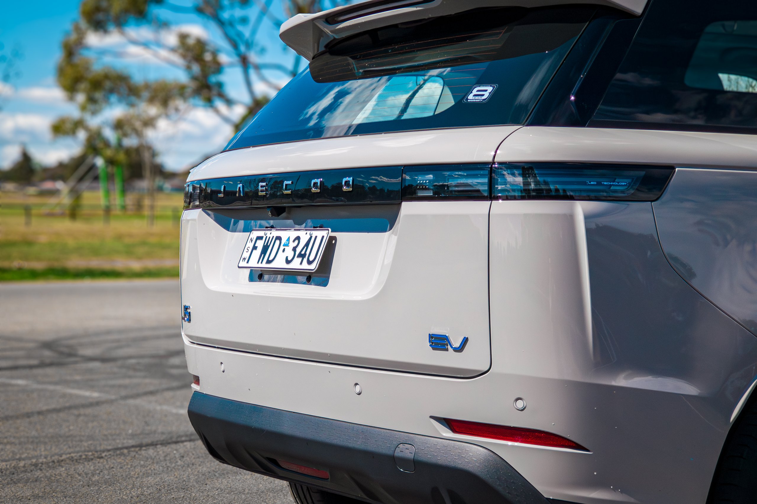 Close-up of the tailgate on the Stone Grey 2026 Jaecoo J5 EV Summit showing JAECOO lettering, light bar and blue EV badge