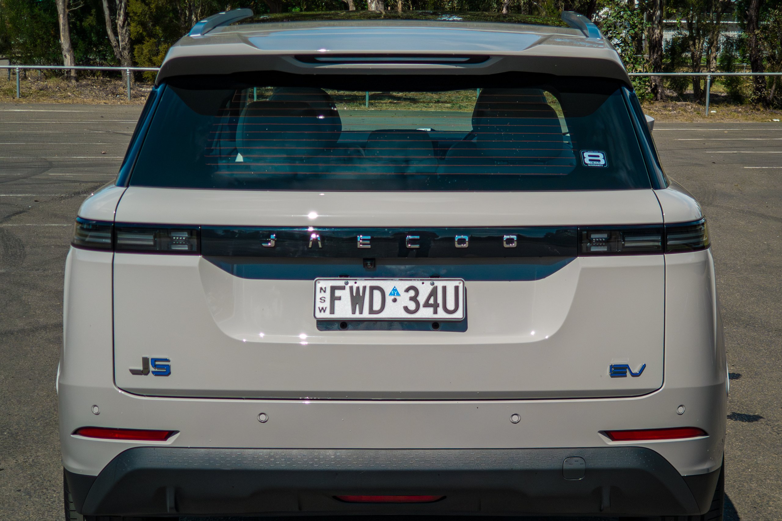 Rear of the Stone Grey 2026 Jaecoo J5 EV Summit showing the full-width light bar, JAECOO lettering and EV badge