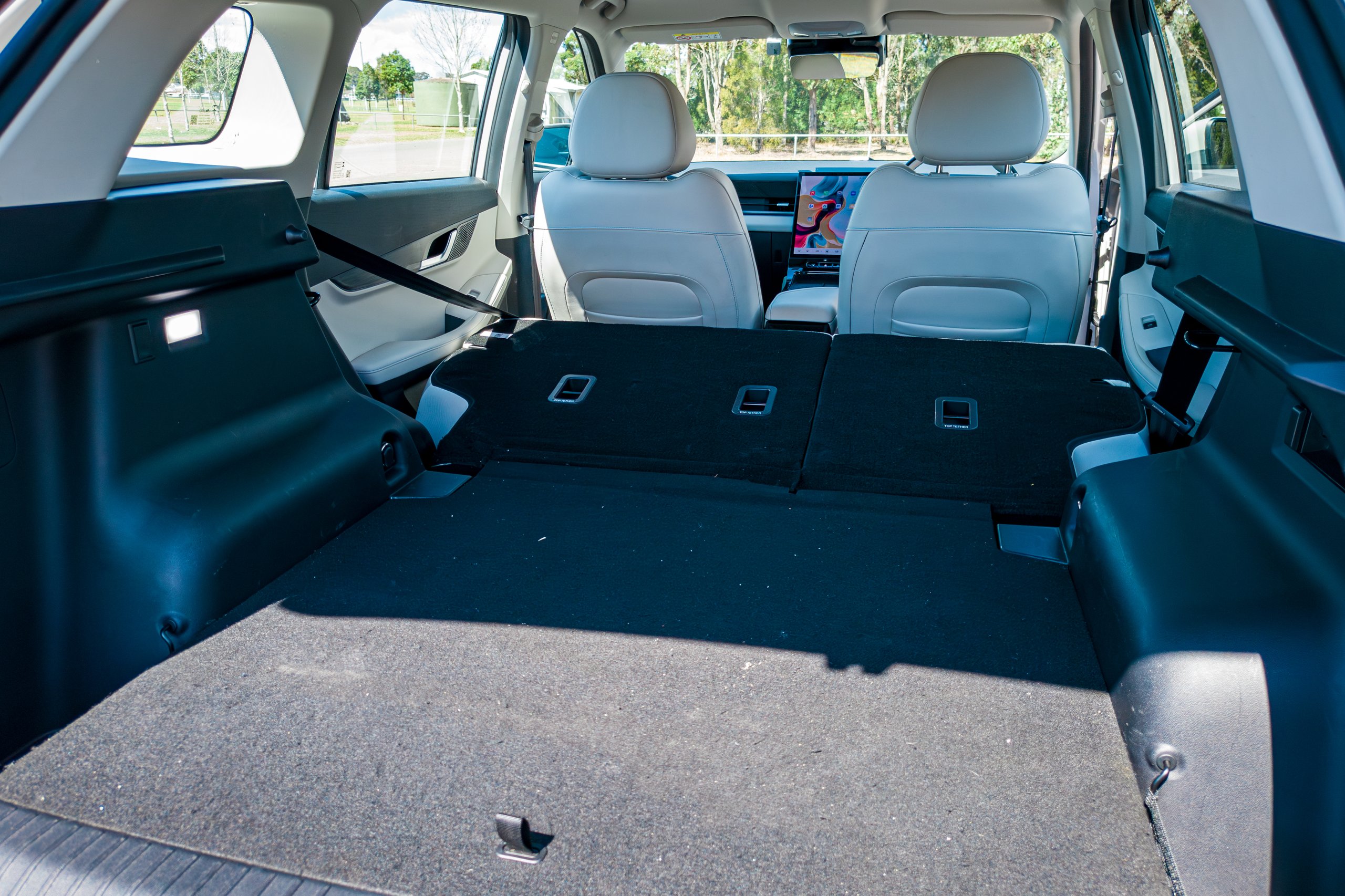 Rear seats folded flat in the 2026 Jaecoo J5 EV Summit showing the long carpeted load floor through to the front seats