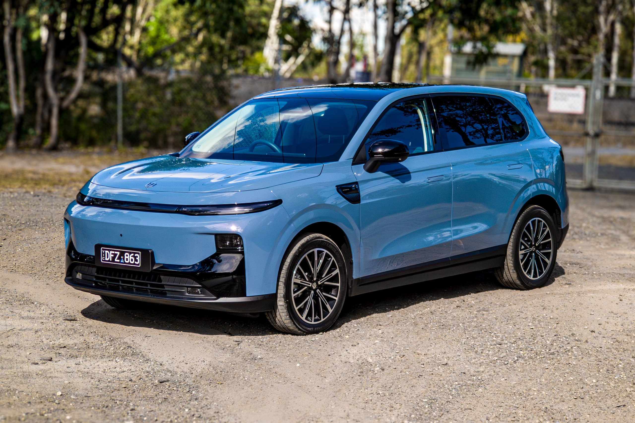 Wide front-left three-quarter view of the 2026 Leapmotor B10 with industrial fence background