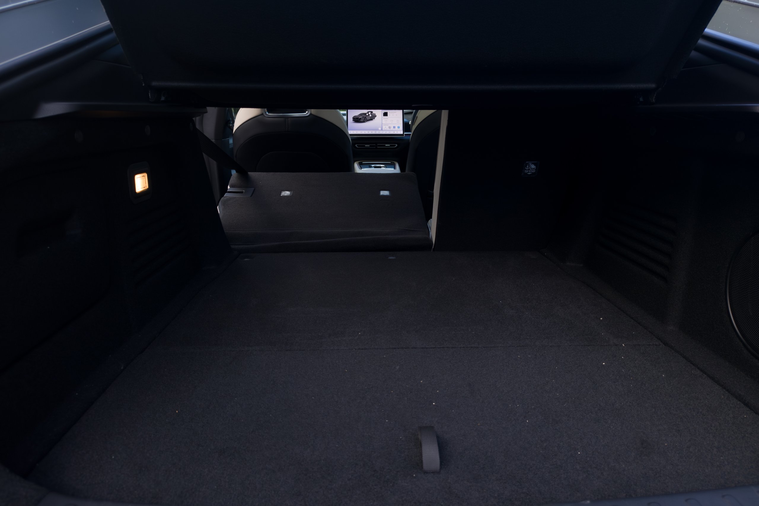 One rear seat folded in the 2026 Mazda 6e GT with the carpeted boot floor behind