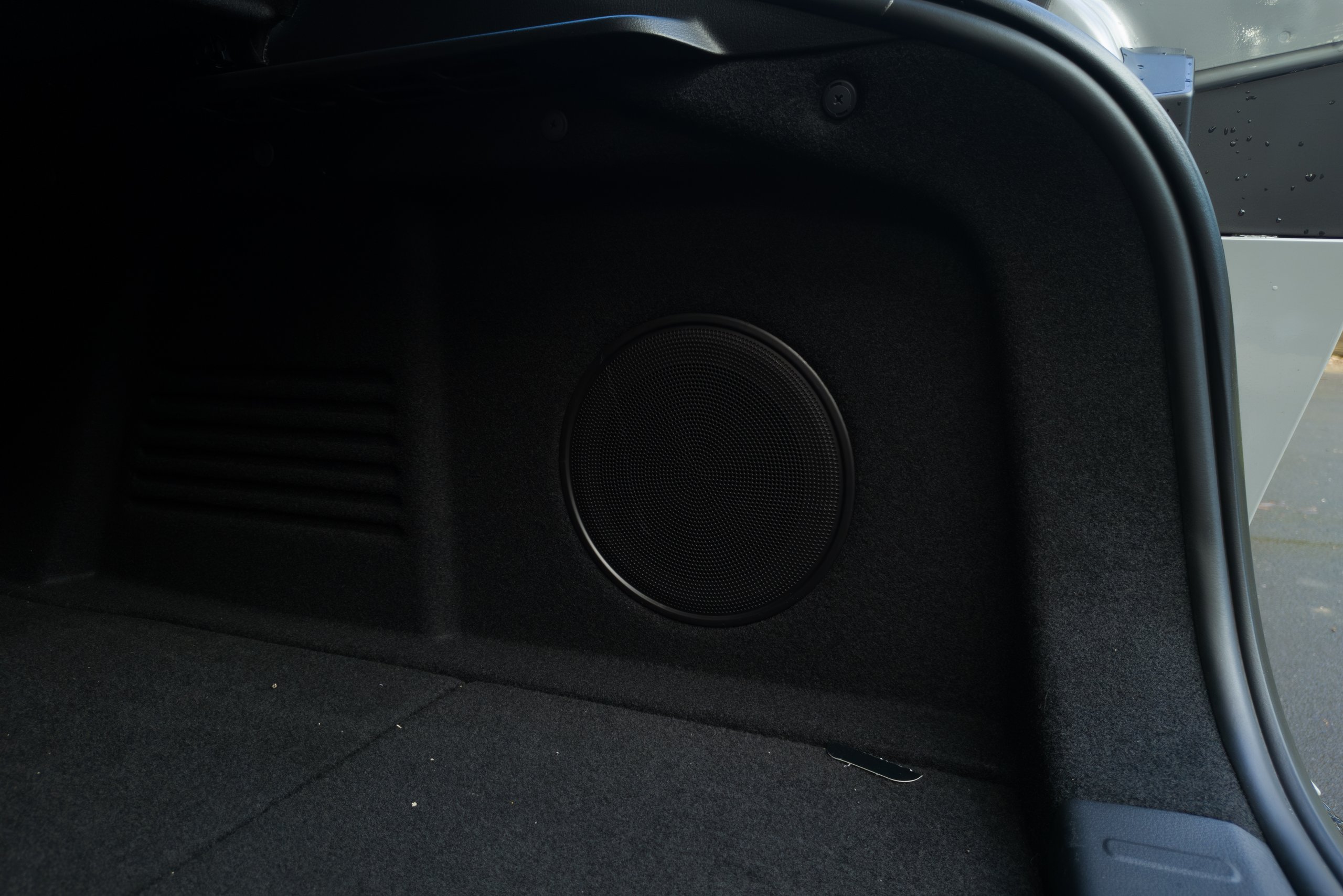 Circular speaker grille mounted in the boot side panel of the 2026 Mazda 6e GT