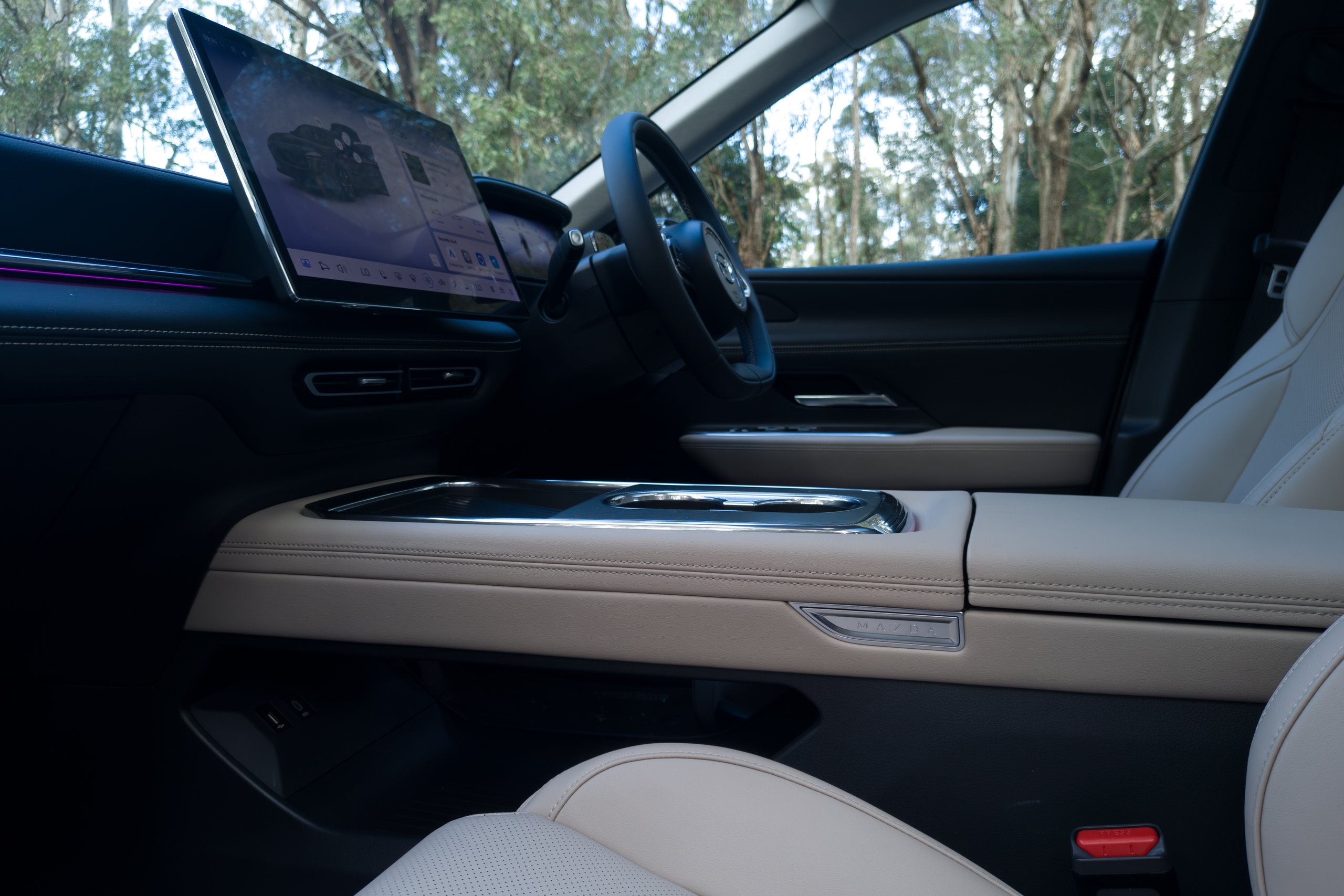 Centre console of the 2026 Mazda 6e GT with cupholders, wireless charging pad and screen