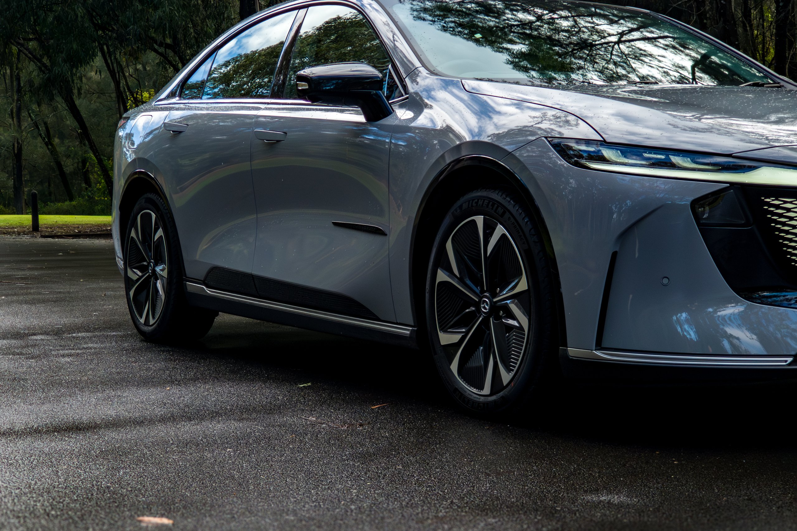 Front driver-side three-quarter view of the 2026 Mazda 6e GT showing wheel and sill detail