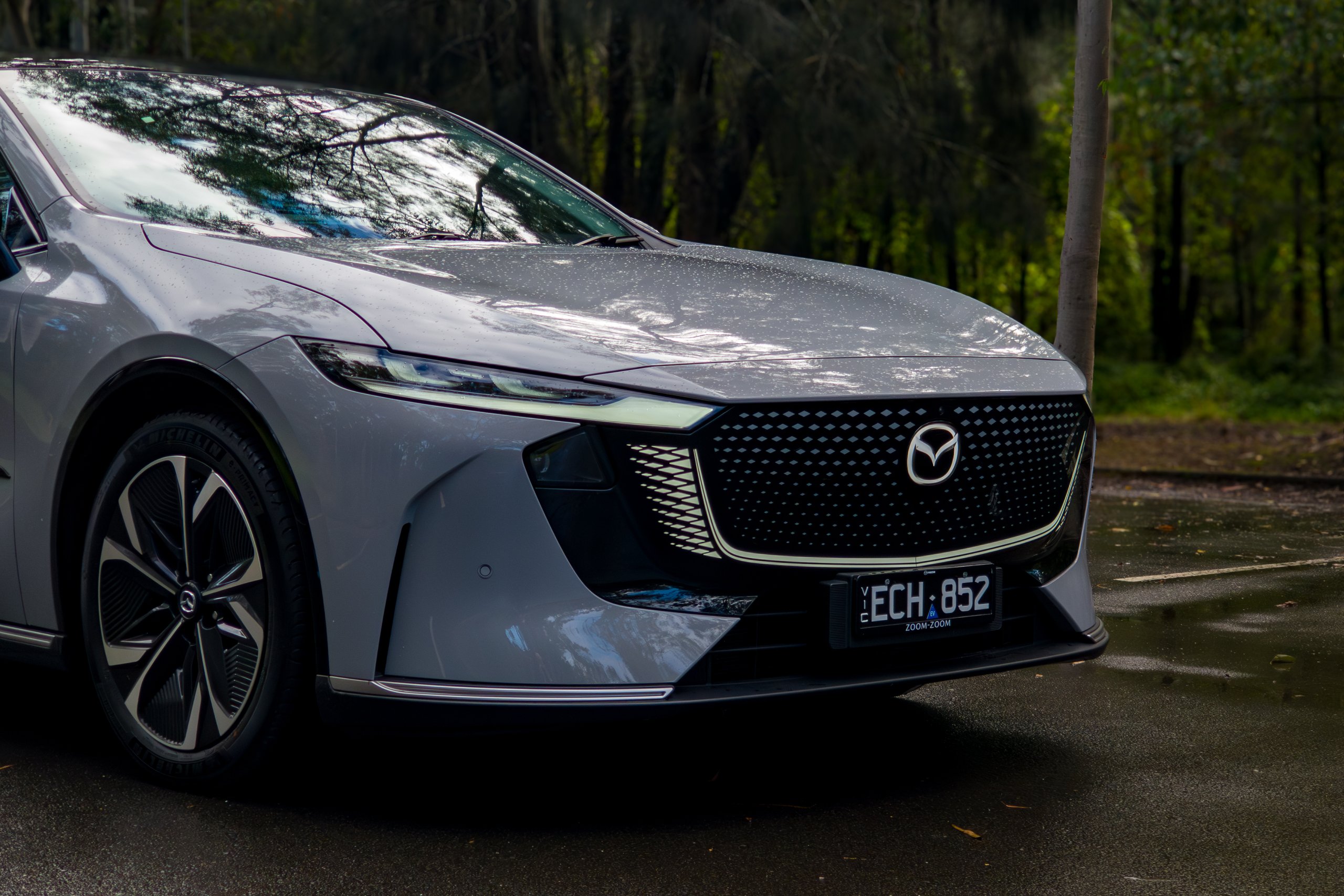 Close view of the 2026 Mazda 6e GT LED headlight, grille panel and front bumper