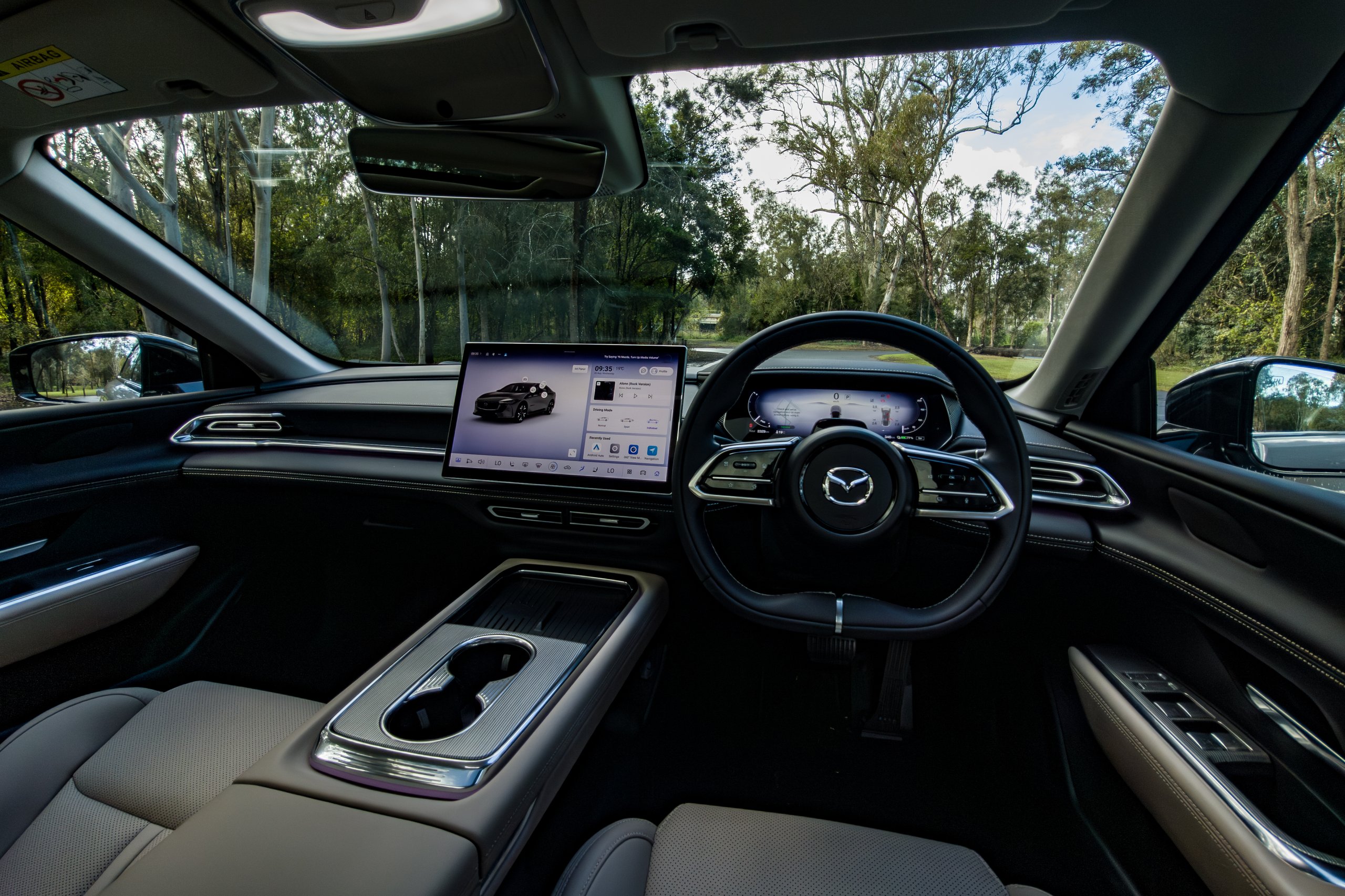 Wide interior view of the 2026 Mazda 6e GT dashboard, steering wheel and front seats