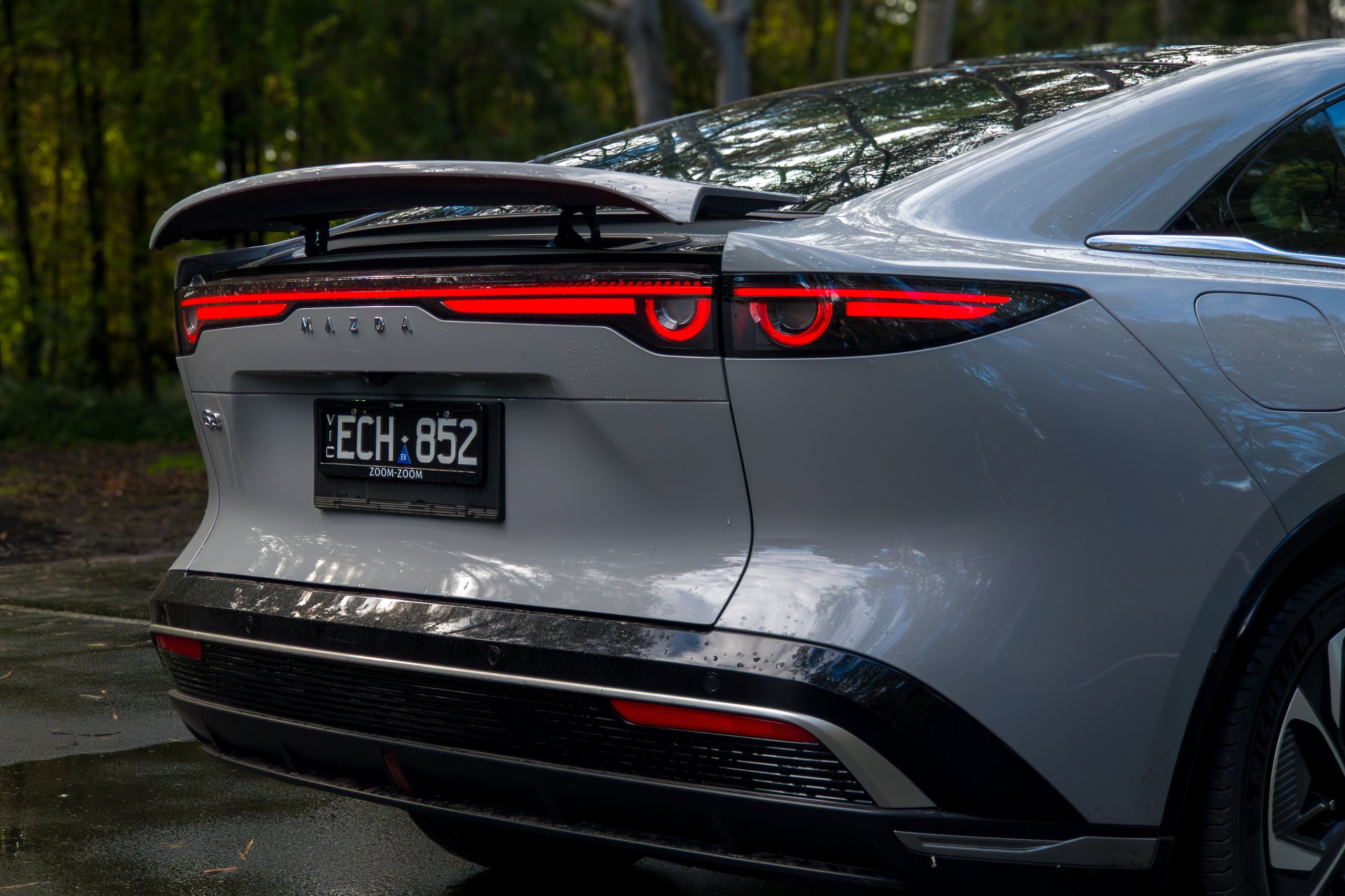 Rear detail of the 2026 Mazda 6e GT showing full-width tail lights and boot-lid spoiler