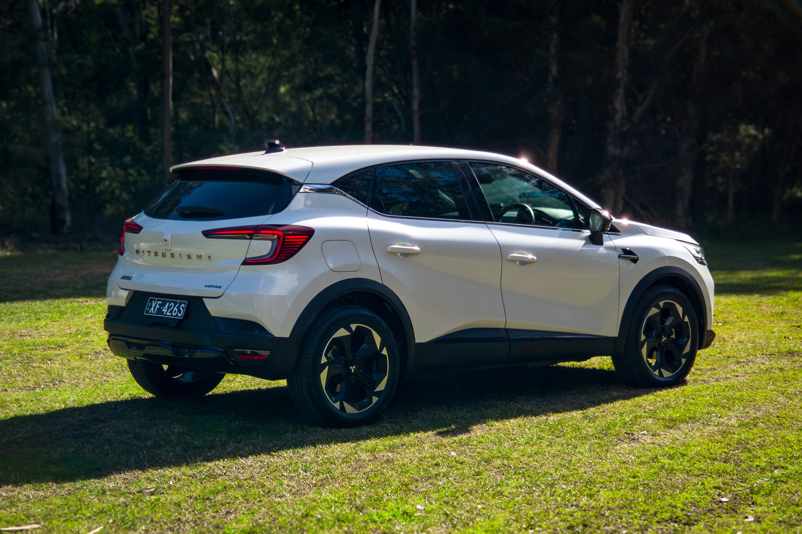 Crystal White 2026 Mitsubishi ASX Aspire rear three-quarter from the driver's side on grass