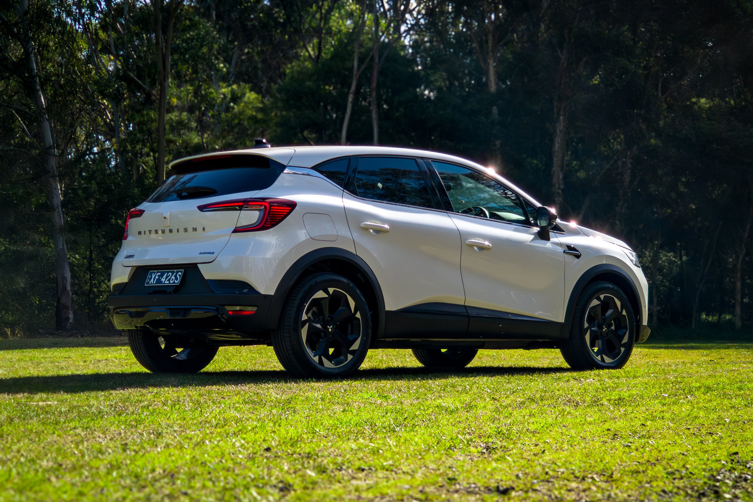 Crystal White 2026 Mitsubishi ASX Aspire rear three-quarter view from the driver's side in bushland