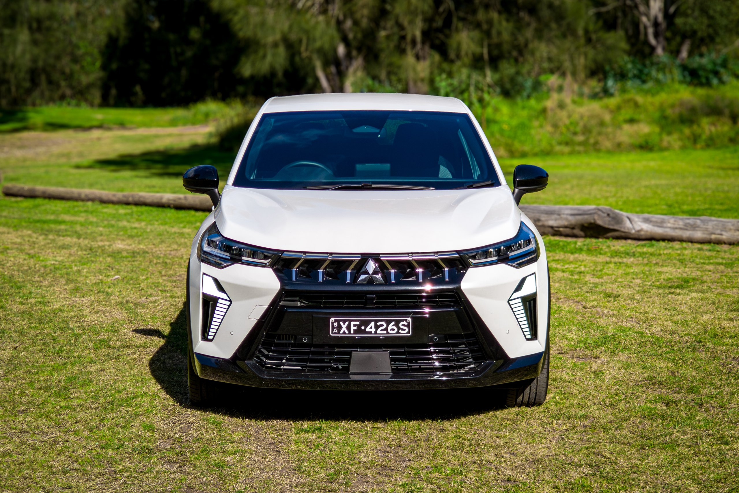 Straight-on front view of the Crystal White 2026 Mitsubishi ASX Aspire parked on grass