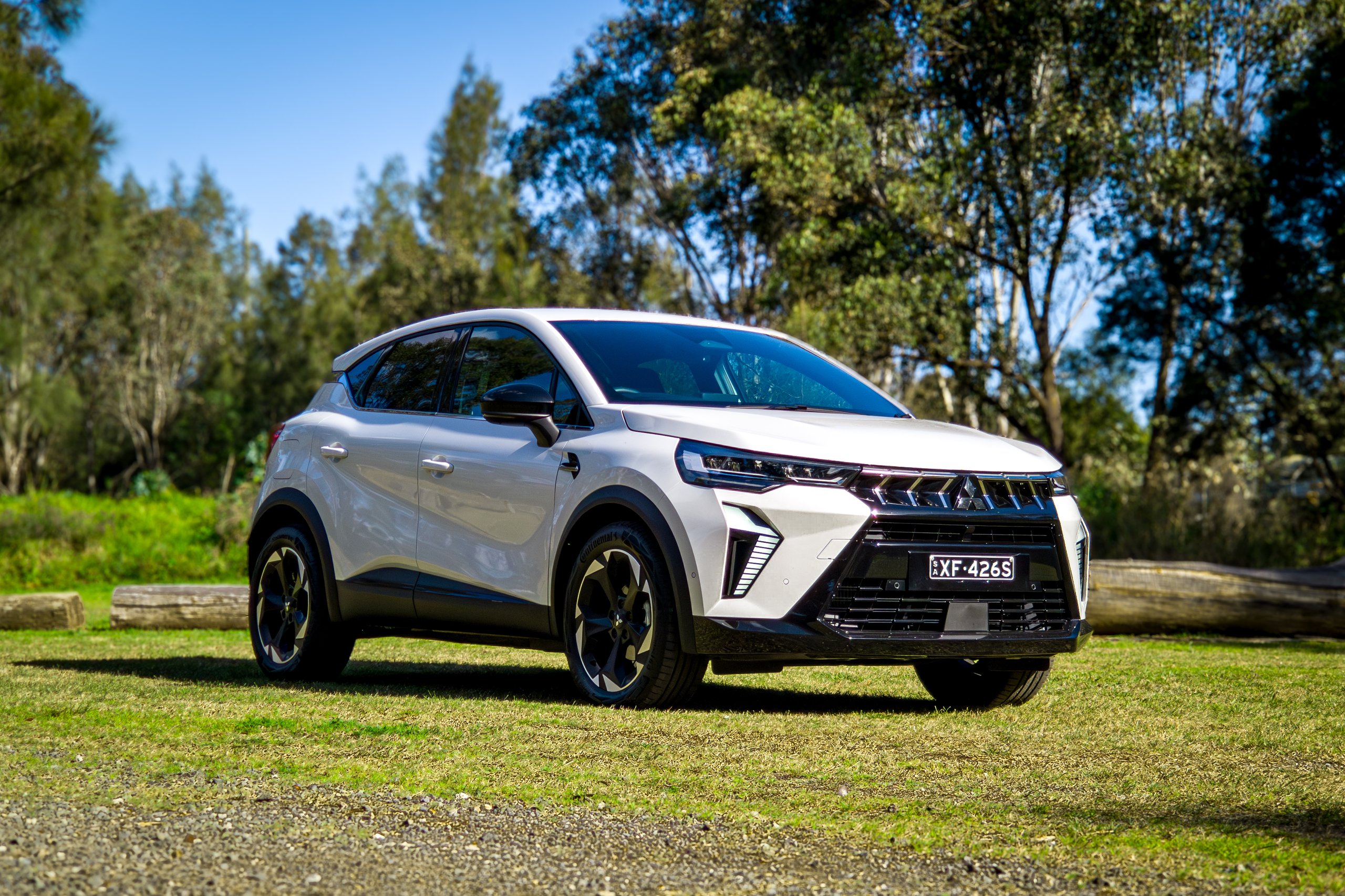 Crystal White 2026 Mitsubishi ASX Aspire front three-quarter view from the driver's side on grass