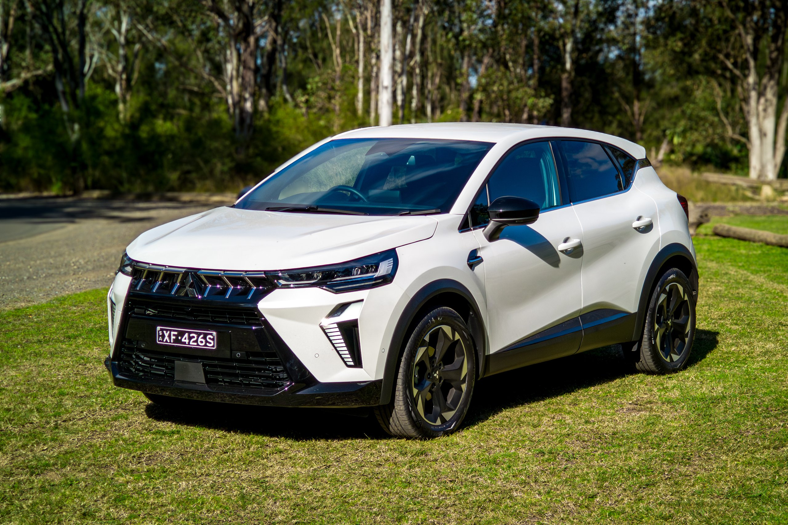Crystal White 2026 Mitsubishi ASX Aspire front three-quarter view in bushland with grille detail visible