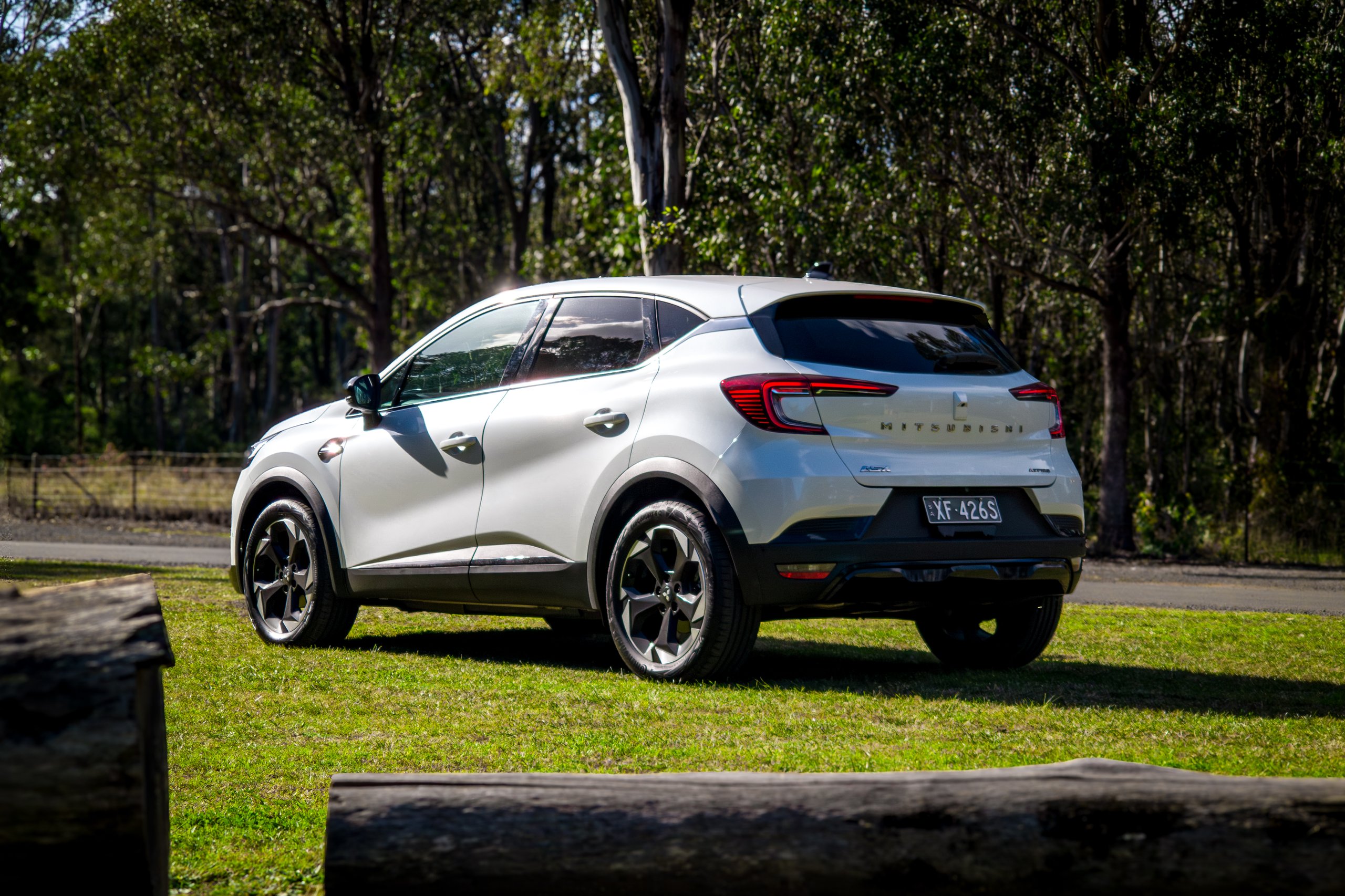 Crystal White 2026 Mitsubishi ASX Aspire rear three-quarter from the passenger side beside bushland