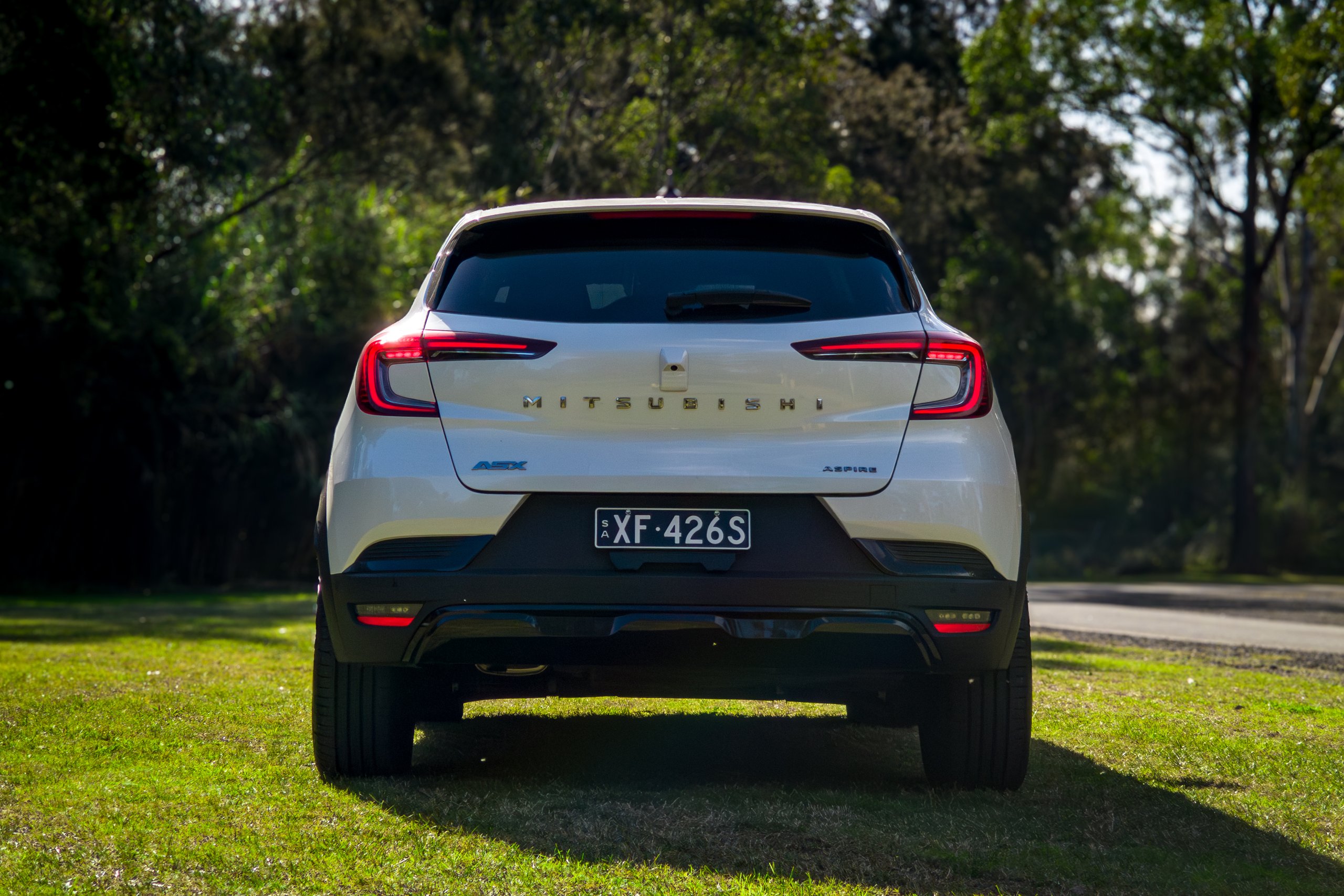 Straight-on rear view of the Crystal White 2026 Mitsubishi ASX Aspire showing tail lights and badges
